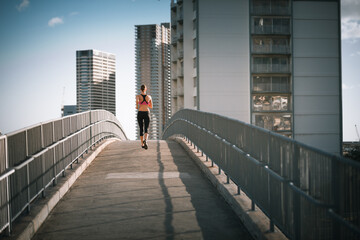 person jogging on city  bridge