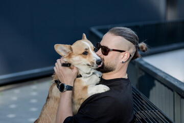 man holds corgi dog.