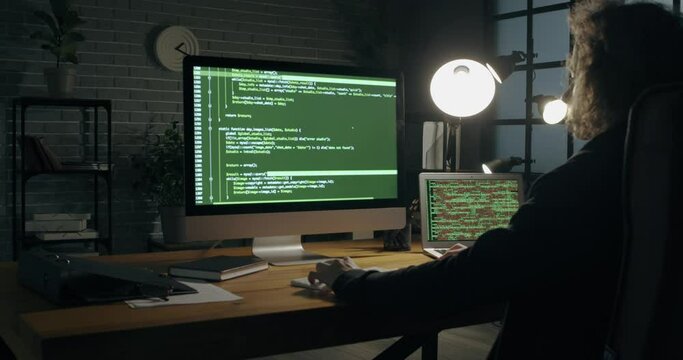 Programmer using computer in dark room