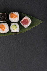 a set of delicious rolls on a dark background of the table, from below there is a place for your inscription