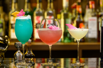 Fresh glass of tropical cocktail with juice at bar counter blur background.