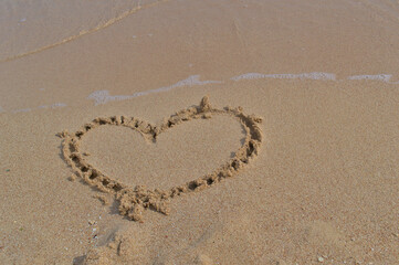 Drawn heart on the sand during summer vacation