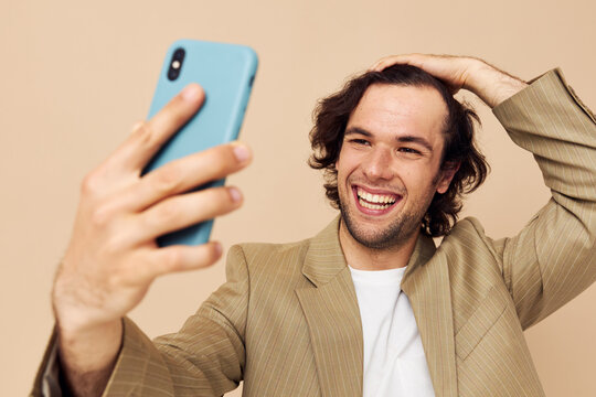Attractive man in a suit posing emotions looking at the phone isolated background