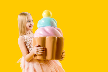 Confectionery. Sweetness. Delicious dessert. The girl holds in her hands a huge cupcake filled with multi-colored cream