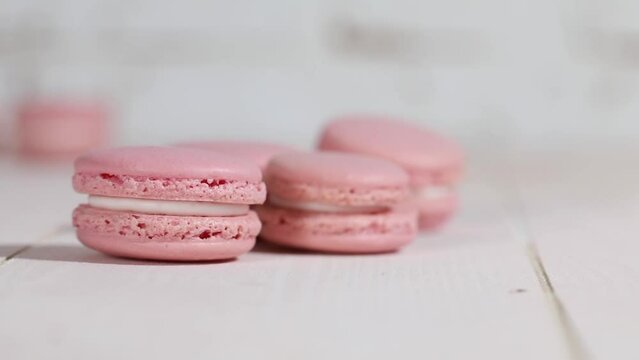 rosa Macarons rollen auf liegende Macarons zu