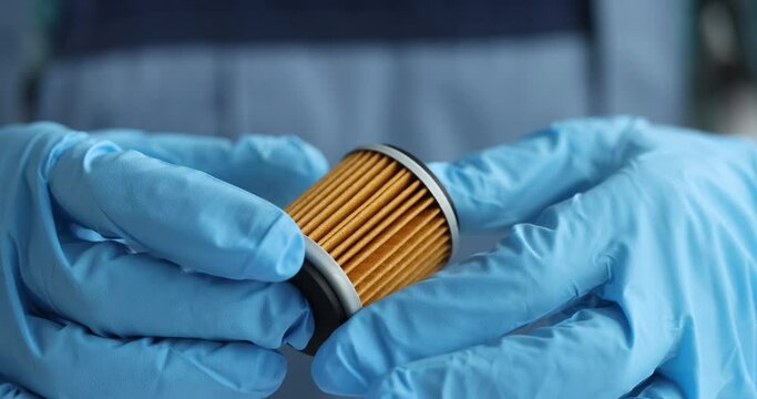 Oil or fuel filter of car in hands of an auto mechanic closeup
