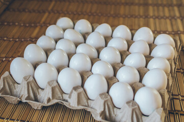 Natural white fresh chicken eggs in cells on table