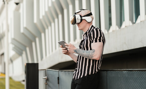 man plays with his smartphone and a virtual reality glasses