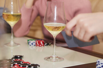 Players of poker game with chips and cards close up. Glasses of champagne. Gambling concept. Candid moment. Selective focus