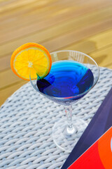 A refreshing blueberry soda fruit drink with some orange on top of the glass. vacation drink Relax by the rooftop pool at one of the hotels in Thailand.