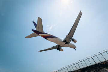 Commercial airplane is flying above clouds. Fast travel around the world. View from below.