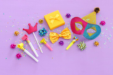 Holidays image of mardi gras masquarade masks over purple background. view from above