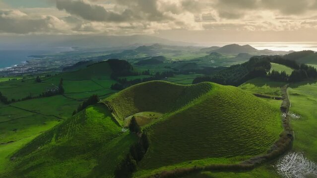 Magnificent nature of the Azores with green meadows, craters and the ocean. Aerial drone view from Miradouro do Pico do Carv o