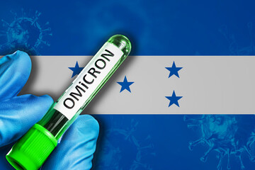 Honduras outbreak of omicron variant. Hand holds a test tube with covid-19 virus omicron in front...