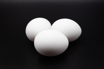 3 white eggs isolated on black background