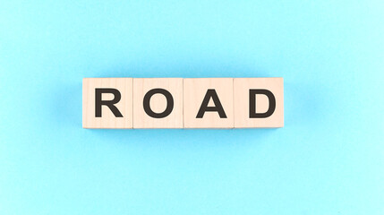 Wooden cube block with text ROAD on the blue background