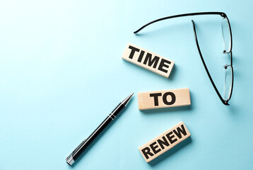 Text TIME TO RENEW concept on wooden block on the blue background