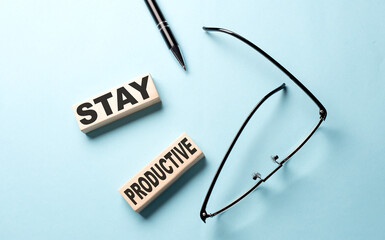 STAY PRODUCTIVE text on the wooden block ,blue background