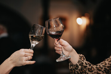 Glass of red wine in hand at a special event, a specific tasting of alcoholic beverages.