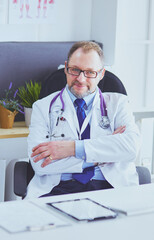 Fototapeta premium Portrait of senior doctor in office sitting at the desk