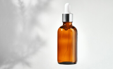 Essential oil in glass bottle with dropper isolated on a gray background with clipping path....