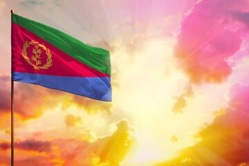 Fluttering Eritrea flag in top left corner mockup with the space for your text on beautiful colorful sunset or sunrise background.
