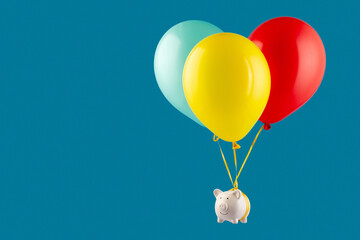 Financial freedom concept. Piggy bank flying on balloons. Blue background. Copy space.