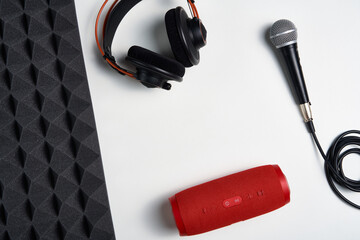 Music, blogging concept background. Microphone, headphones and portable stereo speaker on on white...