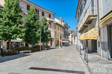 Beautiful street in an old city in Italy. Domodossola, ancient city in northern Italy, historic center with shops, cafes and paving stone. Street degli Osci