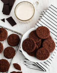 Fresh milk and chocolate cookies on a white plate. Breakfast concept. Top view.
