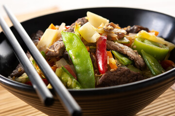 Beef, vegetables and sesame seeds on rustic wooden table.Close up