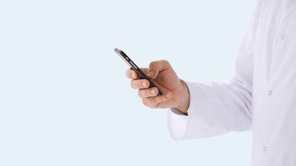 Healthcare, medicine concept: Doctor in white coat is using a smartphone device with touch screen isolated over grey color background