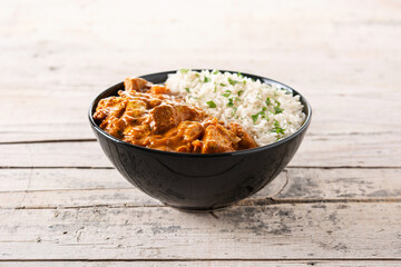 Indian butter chicken in black bowl on wooden table