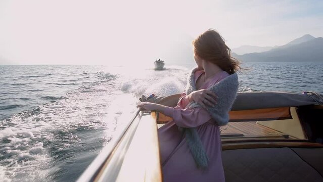 Beautiful Caucasian woman in Luxury motor boat trip at Lake Como at romantic honeymoon. Luxury wedding and holiday concept. 4k high quality slow motion cinematic footage