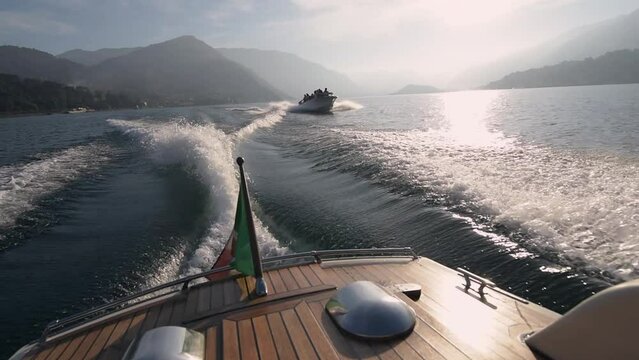 Luxury motor boat trip at Lake Como valley under Italian flag at romantic honeymoon. Luxury wedding and holiday concept. 4k high quality slow motion cinematic footage