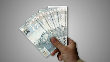 Brazil Real, Reai pile of money in hand 3d illustration. BRL banknotes background concept of finance, economy crisis, inflation and business.