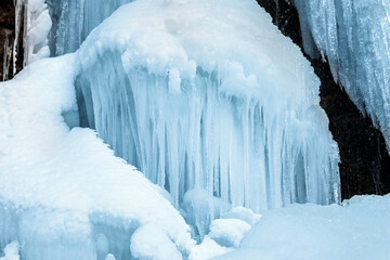Winter cold background with many icicles and snow.