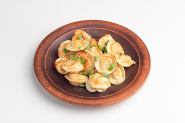 dumplings fried on a wooden plate, isolated, on a white background, Russian cuisine