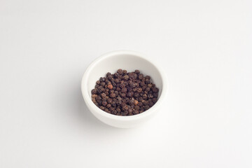 Fototapeta na wymiar black pepper peas, pepper in a bowl, on a white background, isolated