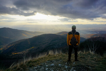 Traveler on top of a mountain at sunset
