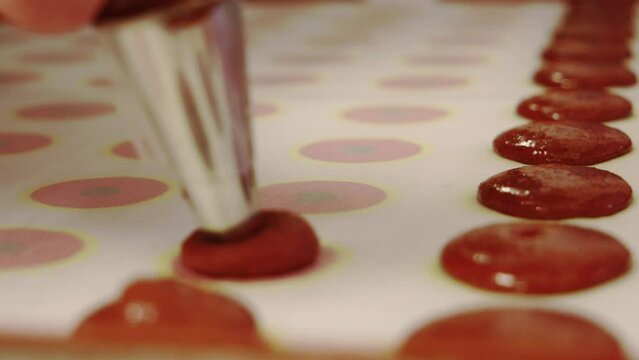 Macarons werden auf das Backblech aufgespritzt