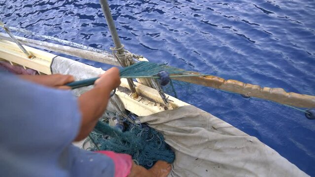 4K.The Fisherman Pulling The Fishing Net In The Sea By The Traditional Method.Fishing Net Is Pulled To The Fishing Boat By Human Power.Hard Heavy Work.Sea Ship Vessel People Coastline Seaboard Man 4K