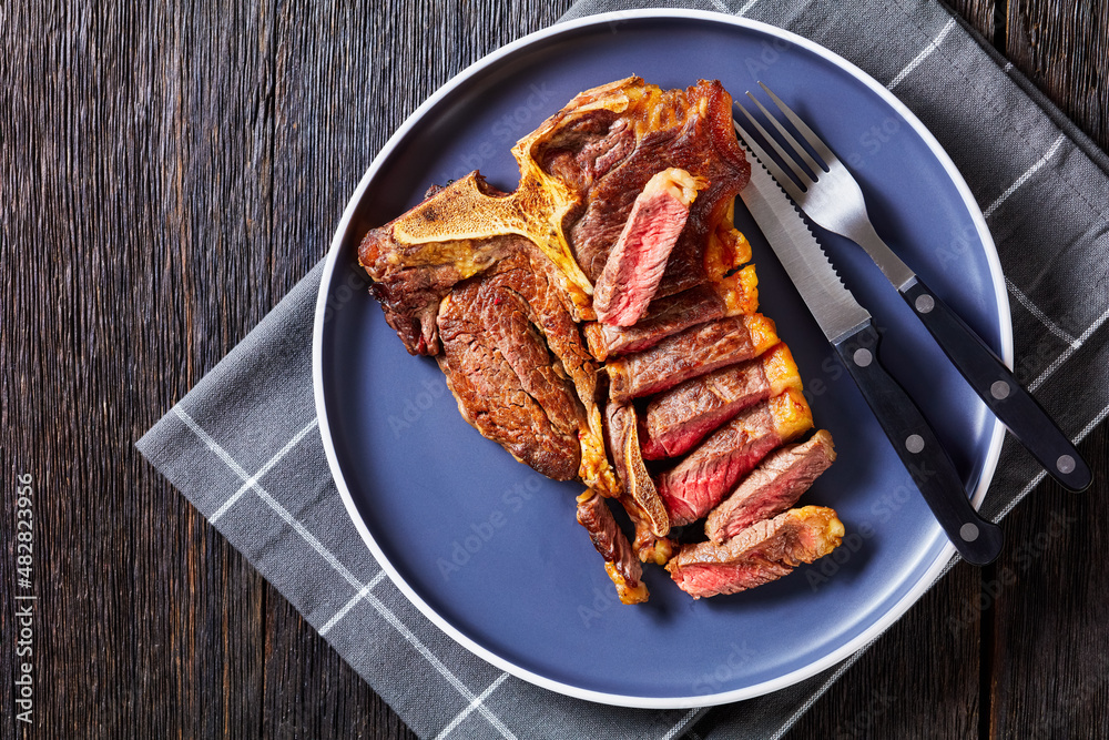 Wall mural fried sliced porterhouse steak on a plate