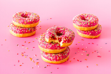 Close up of pink frosted donuts with colorful sprinkles