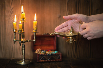 A golden Genie lamp in a woman hands close up.