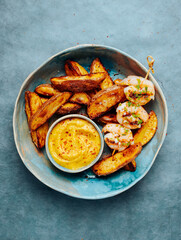 Baked potato, grilled shrimps and yellow romesco sauce