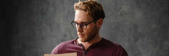 The concentrated man sitting at the table while flipping through papers in the studio