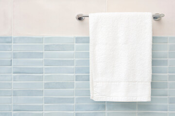 White fluffy bath towel hanging on wall rail in bathroom - Powered by Adobe