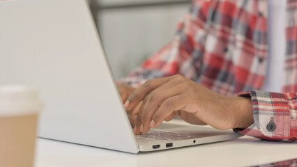 Fototapeta na wymiar Close up of African Man Typing on Laptop