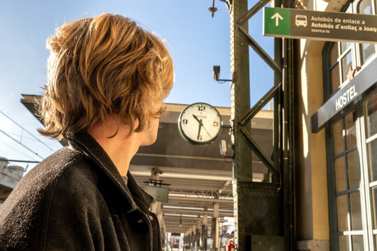 Man From The Back Looking At A Clock In A Train Station. Concept Waiting